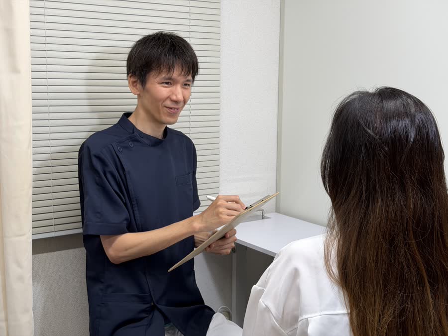 施術者が問診票を手に患者へカウンセリングしているようす